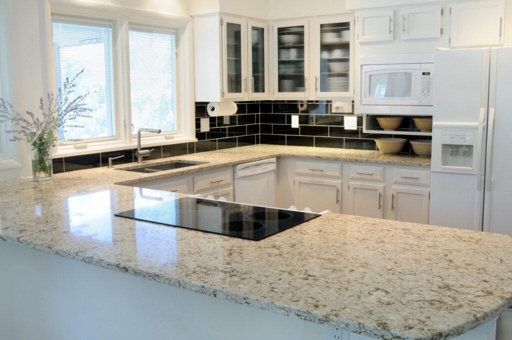 a kitchen with white cabinets and granite counter tops