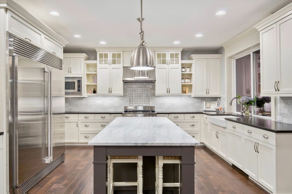 a kitchen with white cabinets and a large island